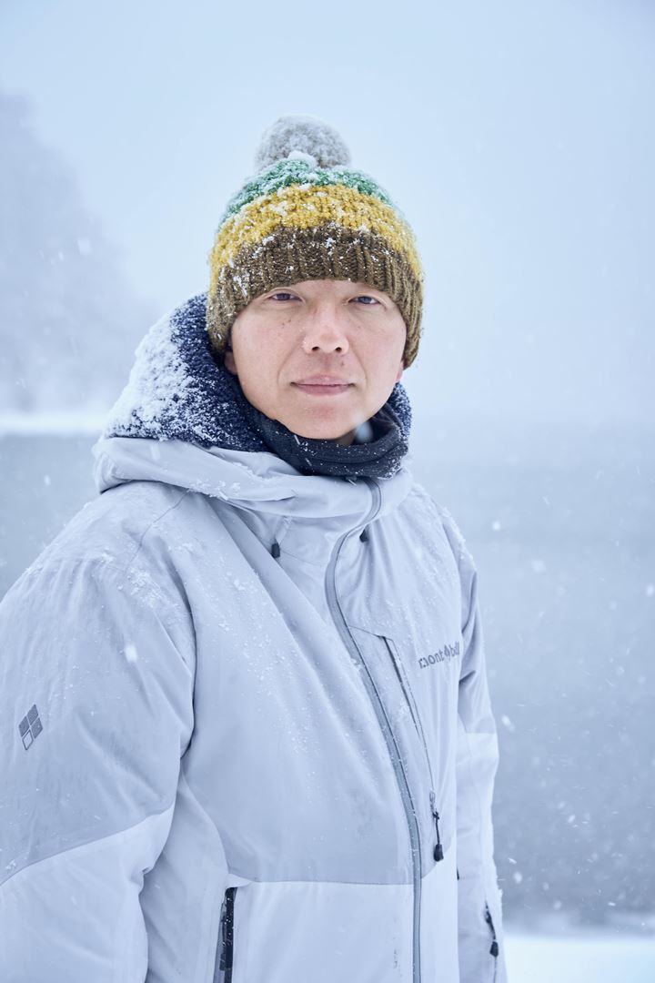 『氷血』メイキング写真　ポンポン付きニット帽をかぶり、雪に包まれている内藤監督